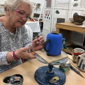 A older woman working on bespoke pottery 