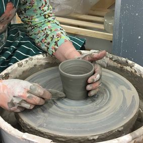 A woman working on a pottery wheel