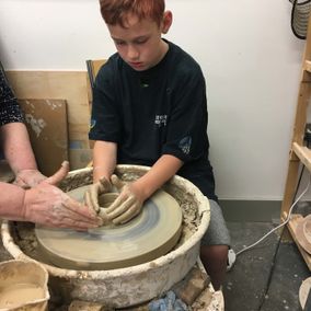 bespoke pottery being designed by a boy with some help